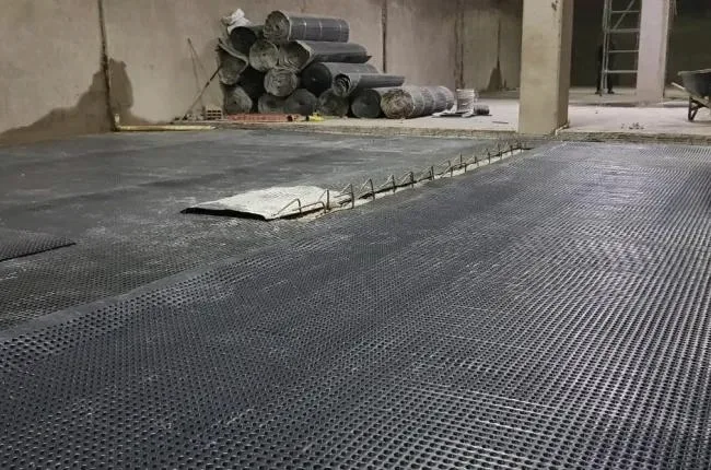 Despliegue de lámina drenante en una superficie de obra
